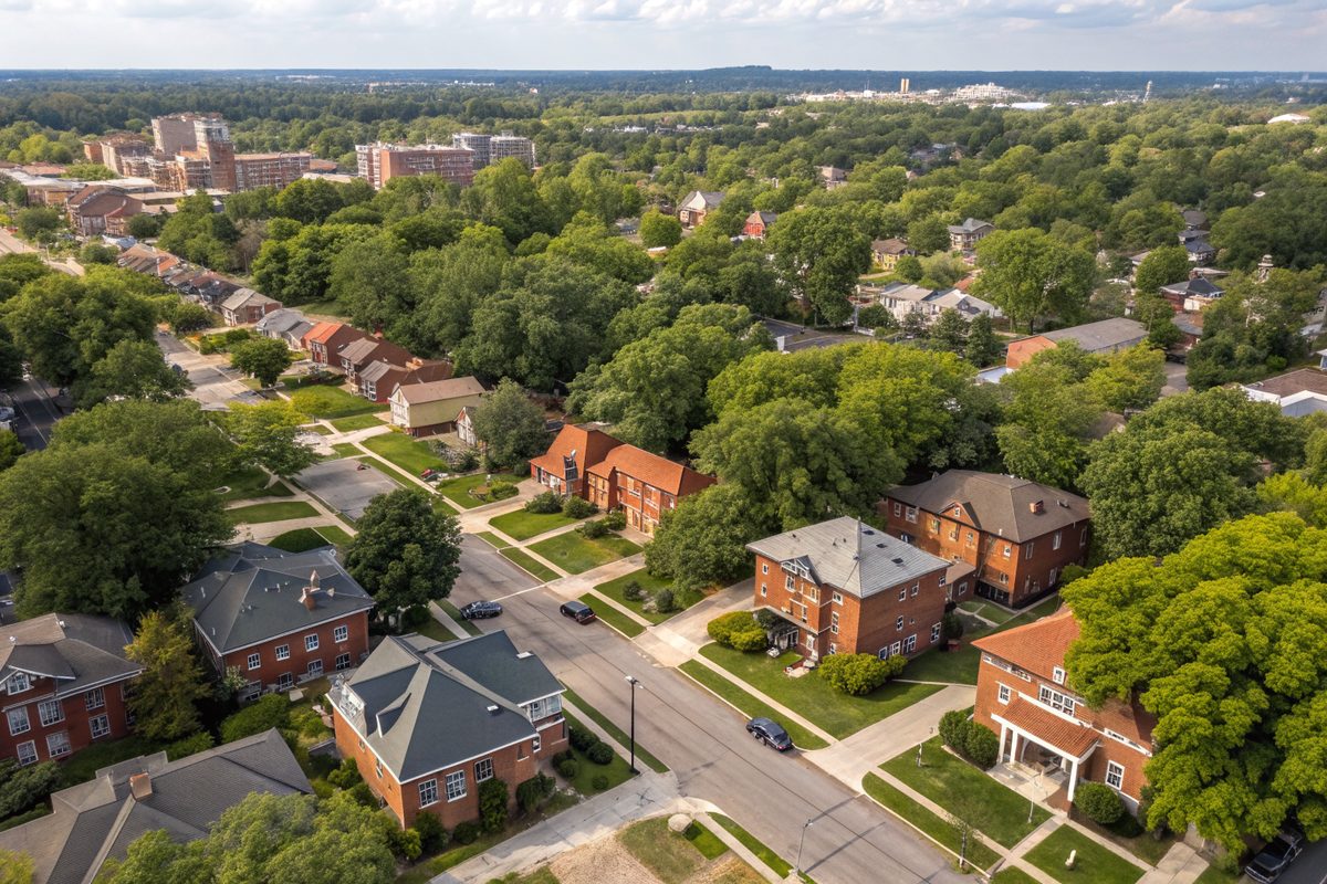 Aerial view of an older neighborhood of red brick houses and shade trees